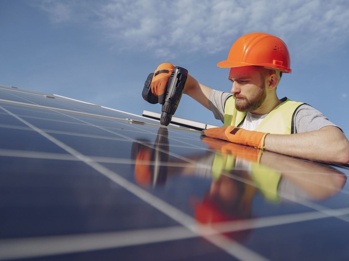 Technician fastening solar panels during installation